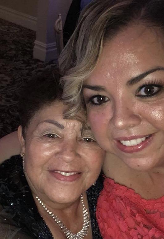 Two joyful women share a moment, showcasing their strong family bond at a special event.