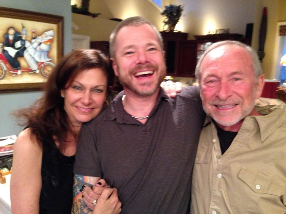 Three friends share laughter and happiness while posing together in a warm, inviting space.