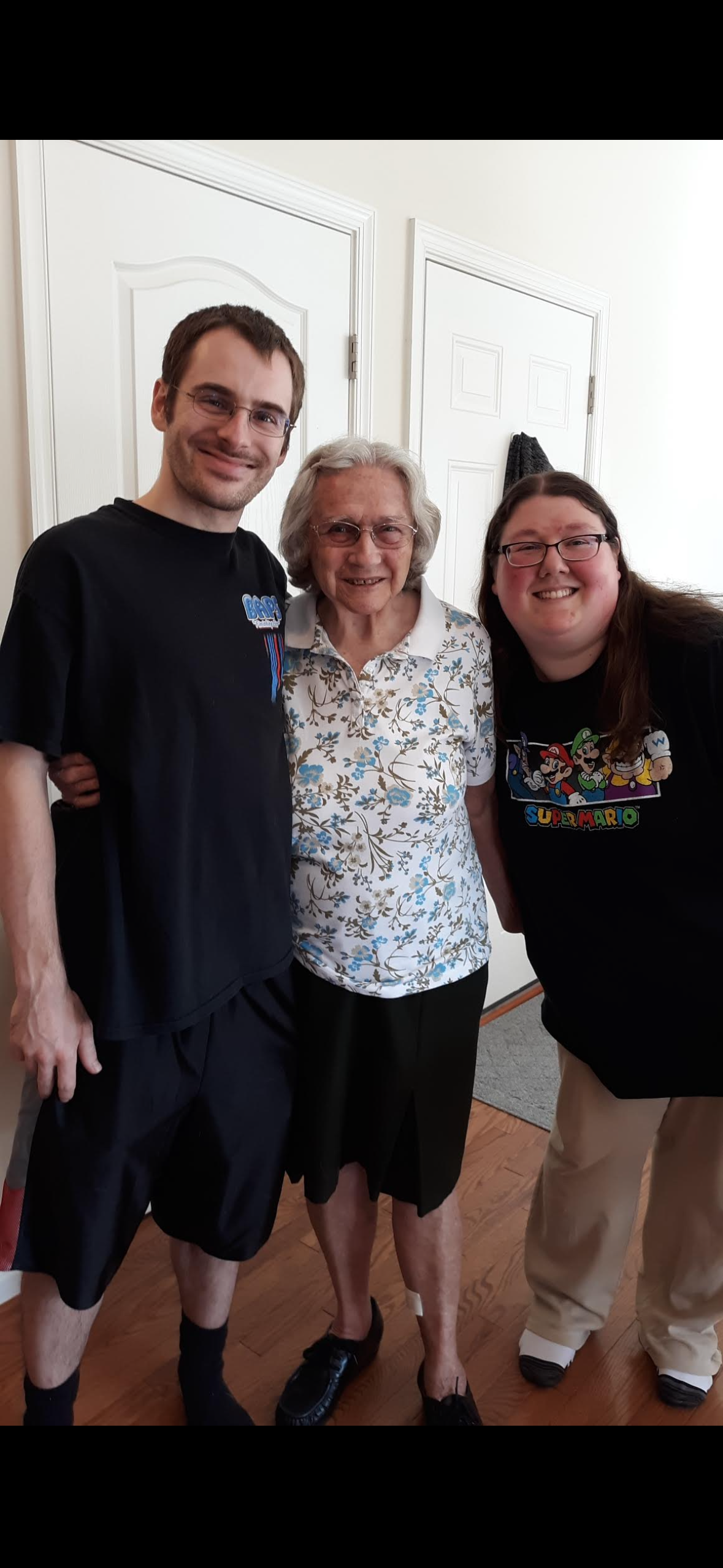 Two grandchildren celebrate a joyful moment with their grandmother in a cozy home atmosphere.