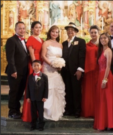 Guests in elegant attire gather for a wedding ceremony inside a stunning church, smiling warmly.