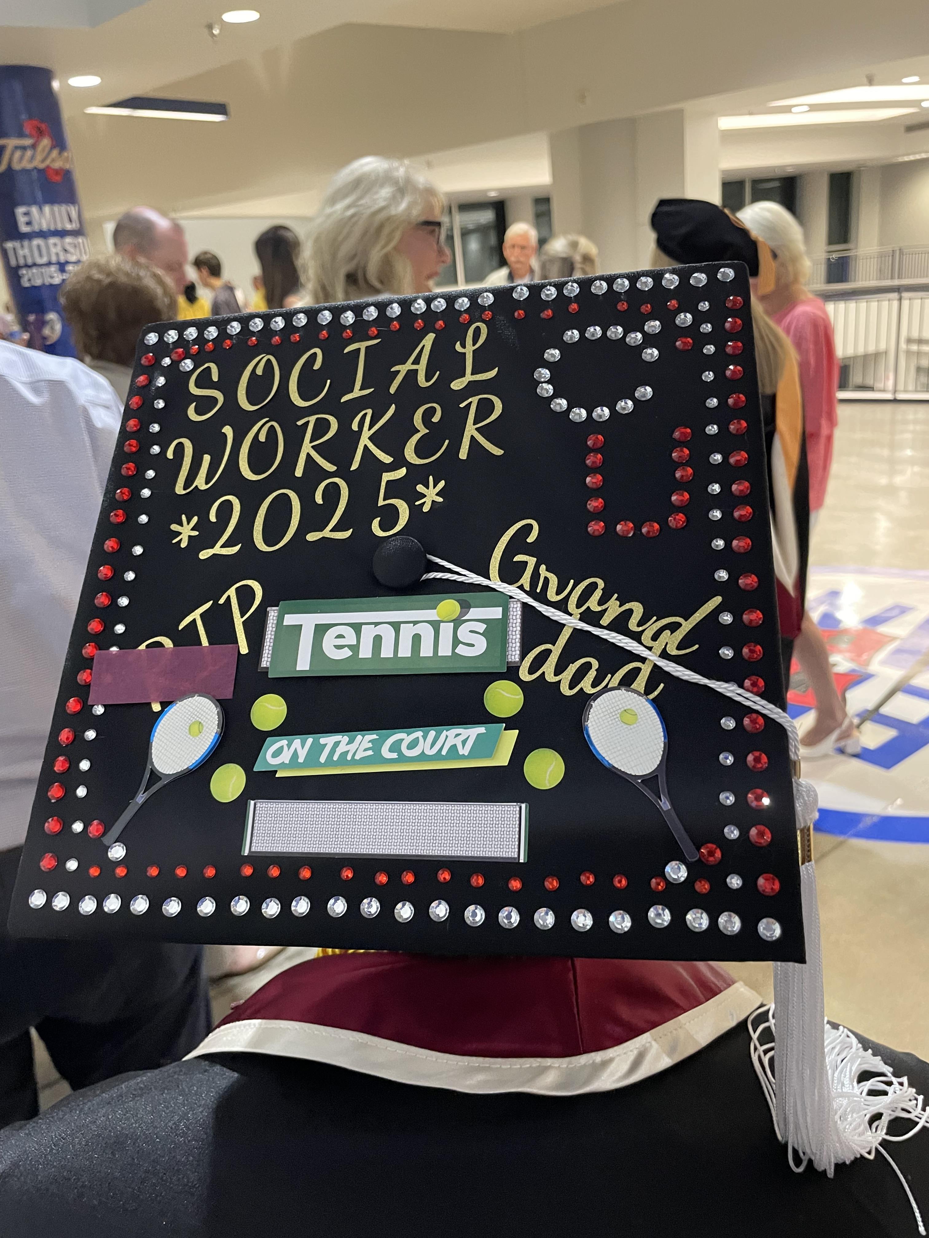 Graduate celebrates achievement with a creatively decorated cap featuring tennis elements.