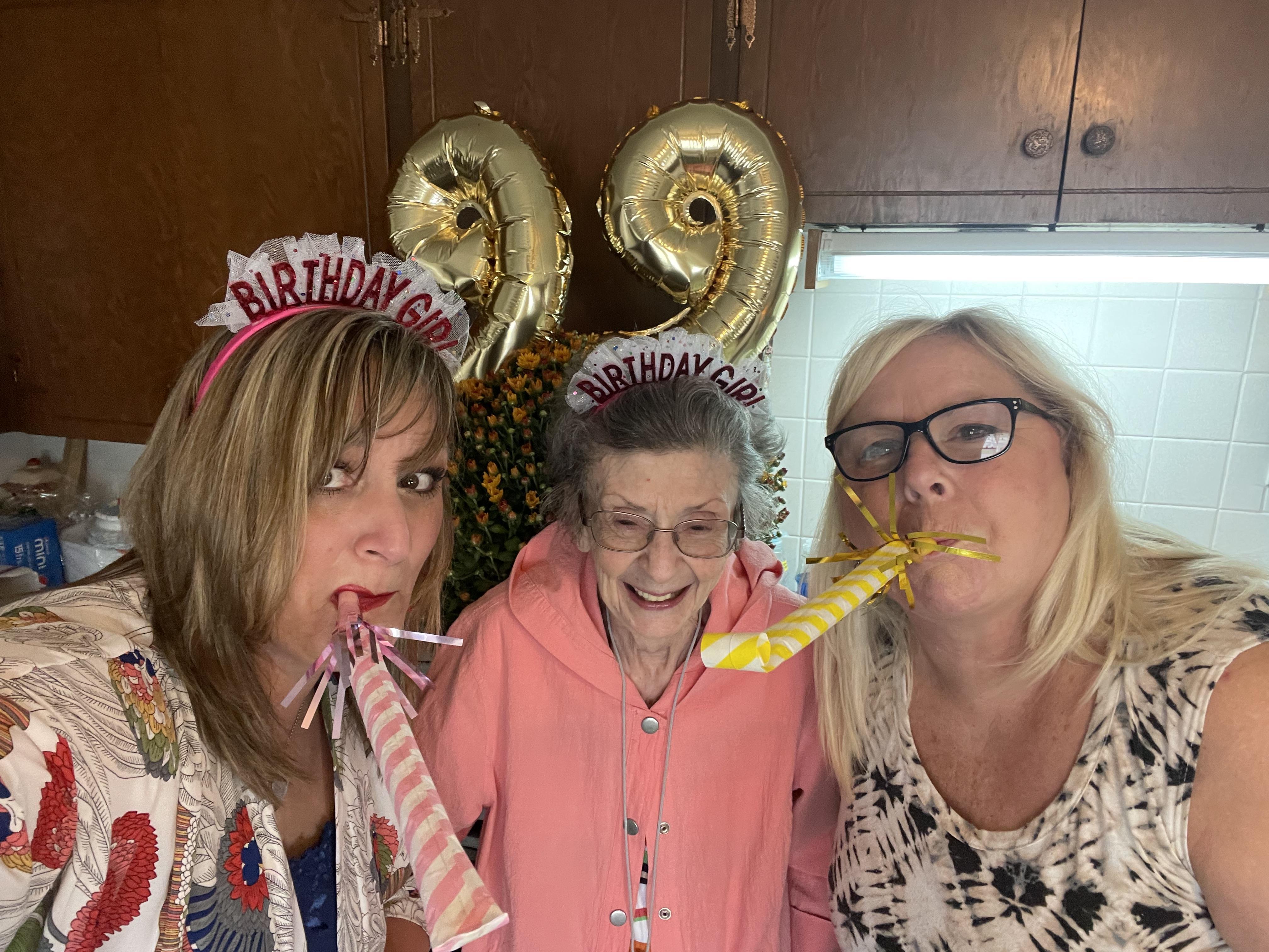 Family celebrates a special birthday together, joyfully wearing party hats.