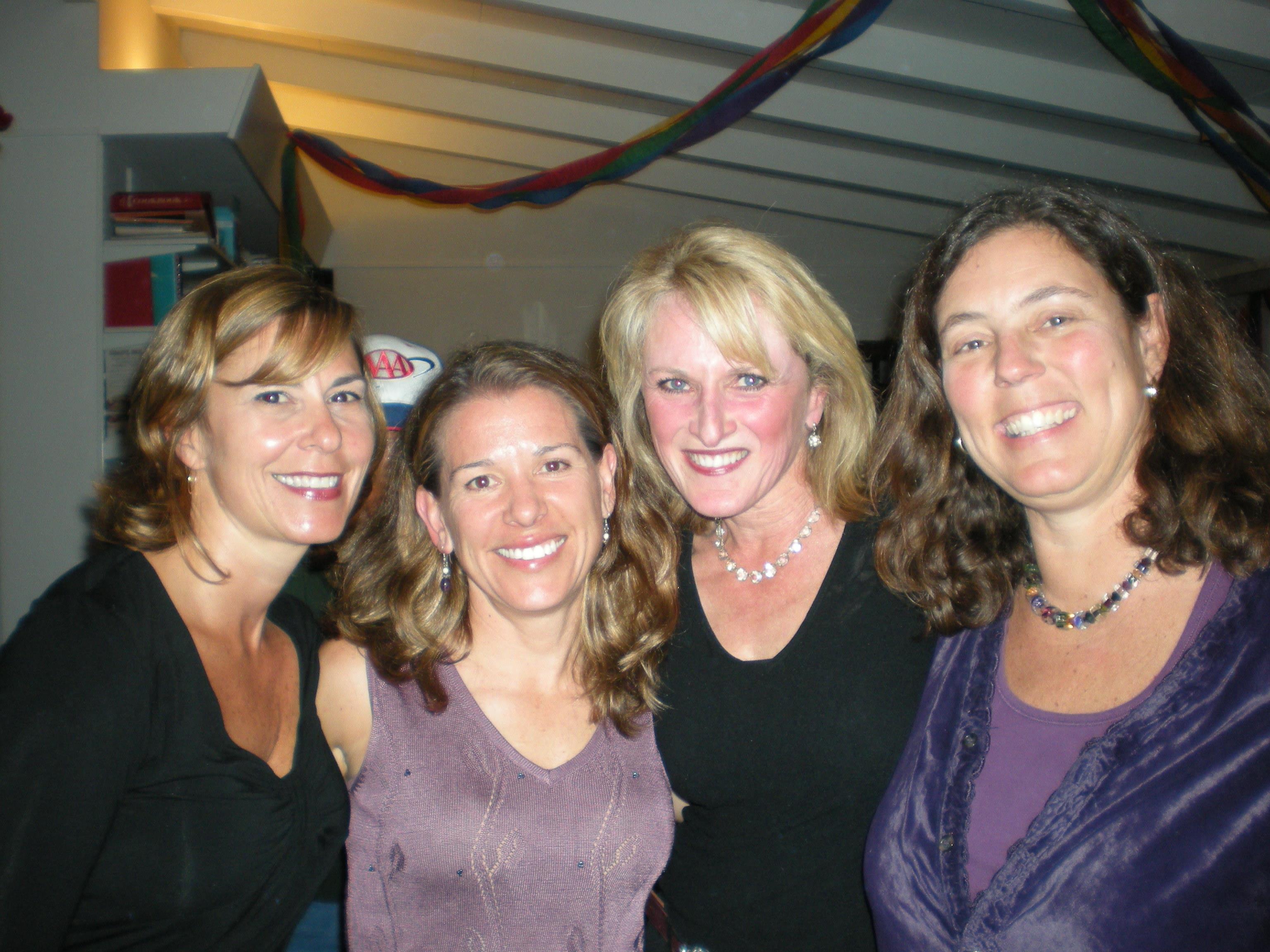 Four friends enjoy each other's company at a festive gathering, sharing smiles and laughter.