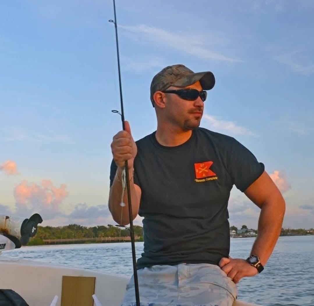 Fisherman enjoys a calm moment on a boat at sunset, casting his line in the serene water.