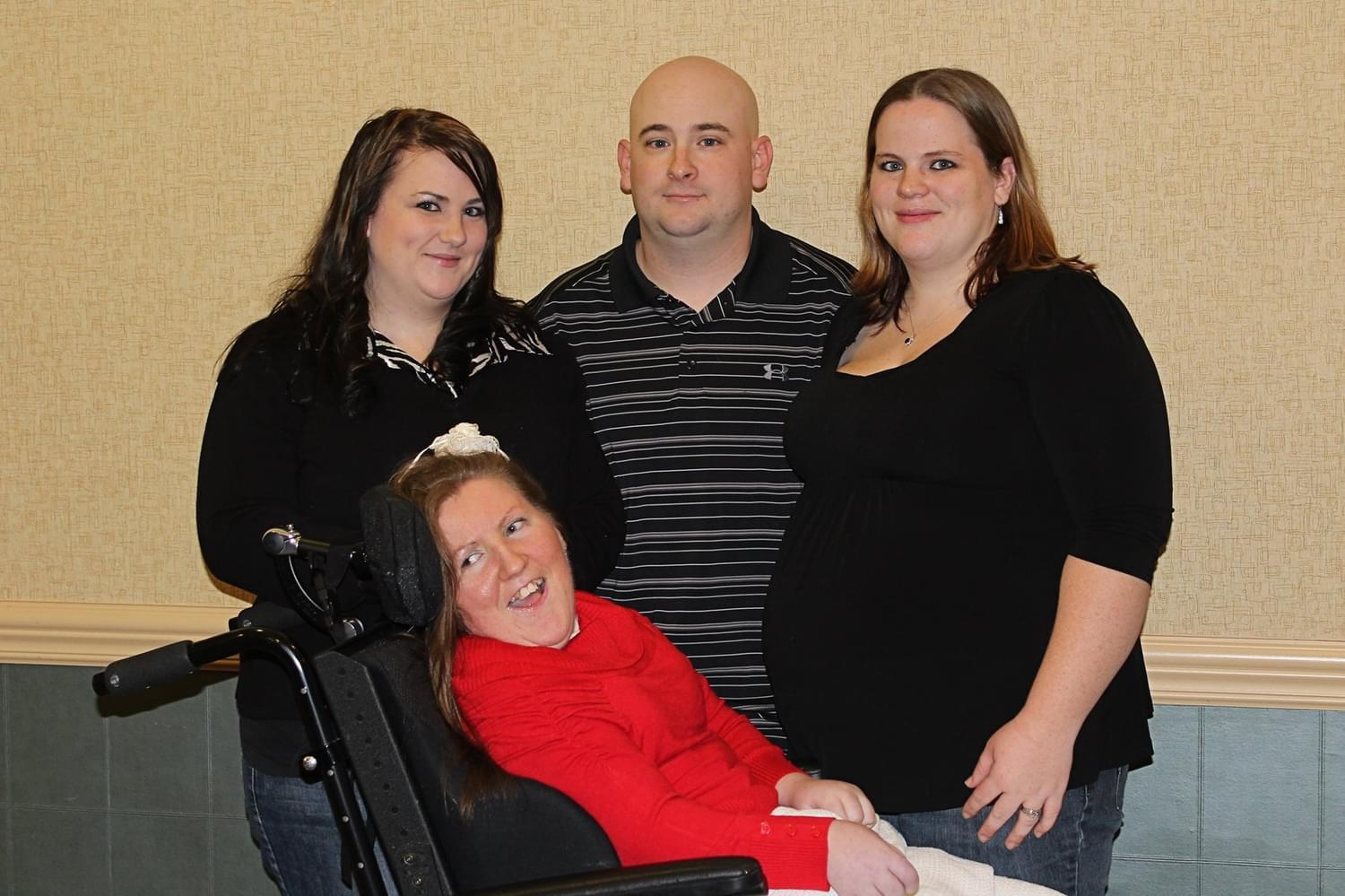 Four family members celebrate together, highlighting joy and support during a gathering indoors.