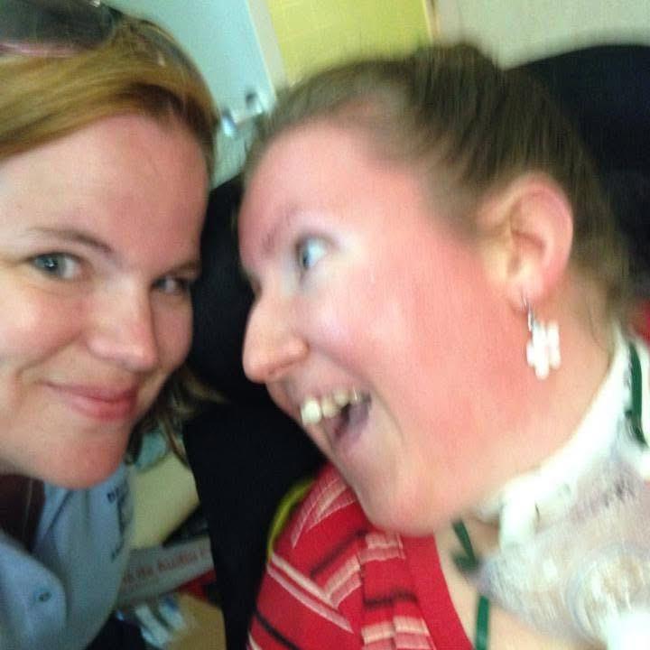 Two friends share a cheerful moment, capturing smiles and laughter while relaxing indoors.