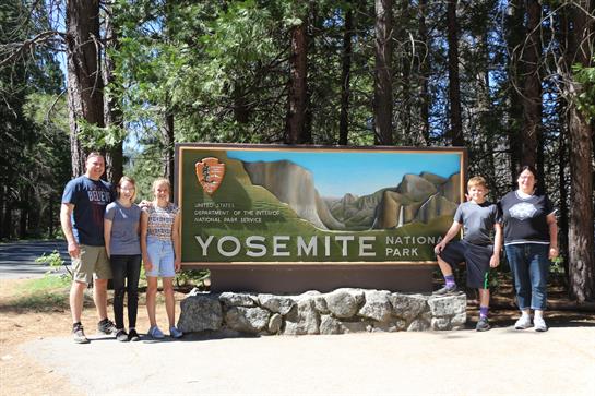A group of people posing in front of a sign