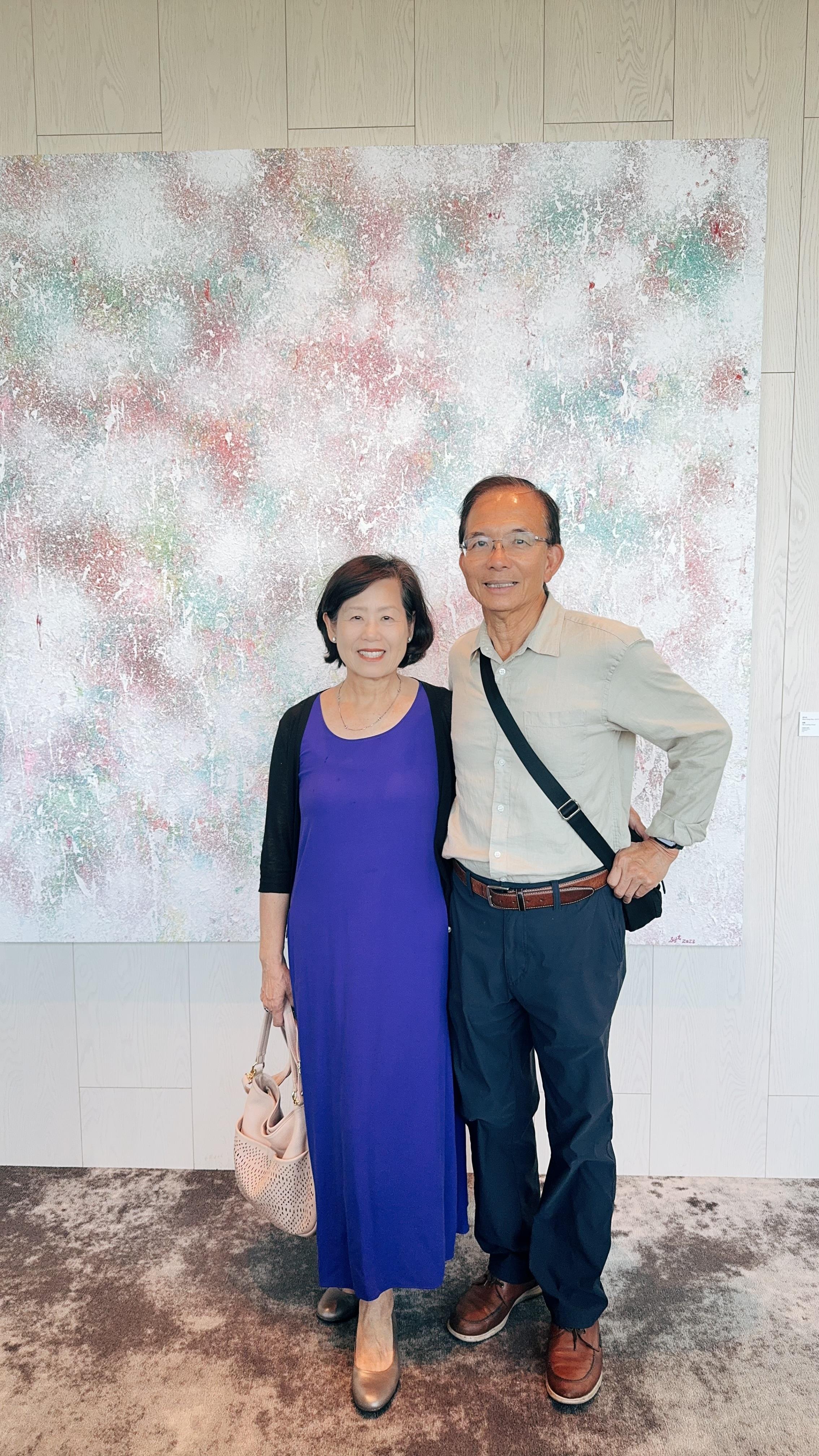Couple smiles while standing close together in a contemporary art gallery, enjoying the atmosphere.