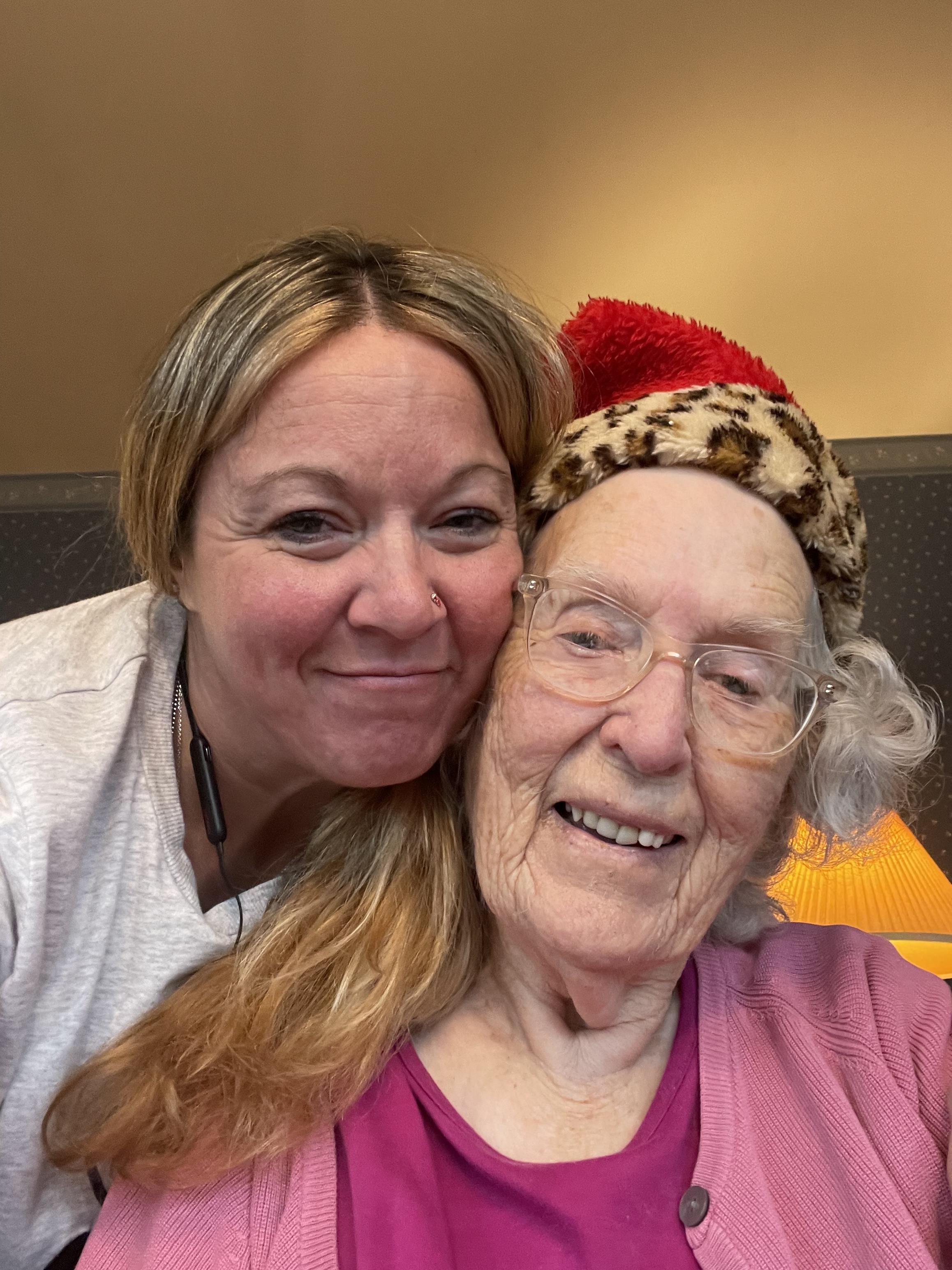 Two women share a joyful moment, showcasing warmth and connection during a festive celebration.