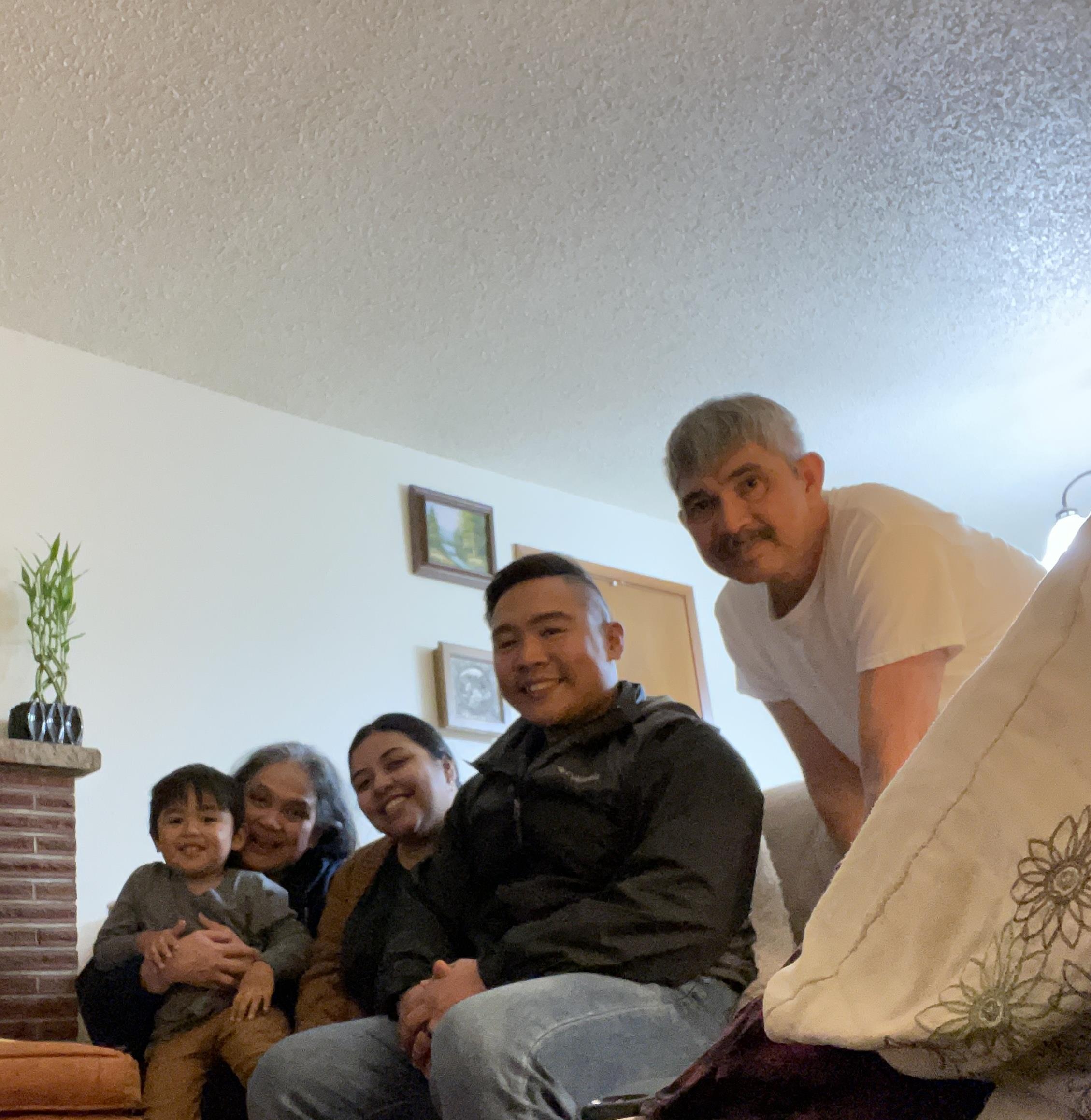 Family members gather and smile for a memorable moment in a comfortable living room space.