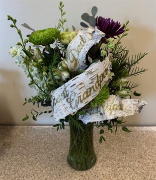 A vase with flowers and a sign