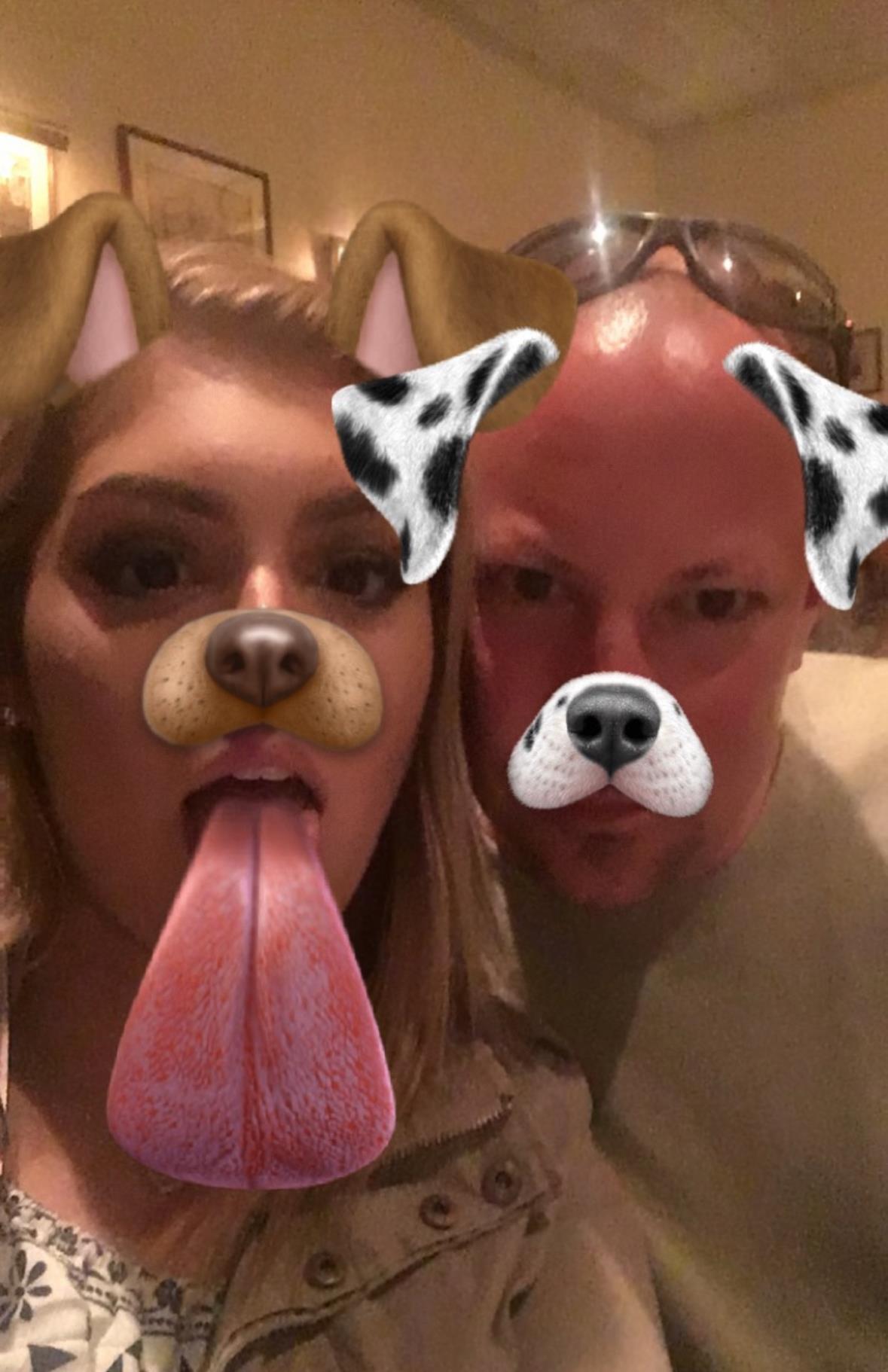 Two individuals are enjoying a playful moment, using fun dog filters to enhance their expressions.