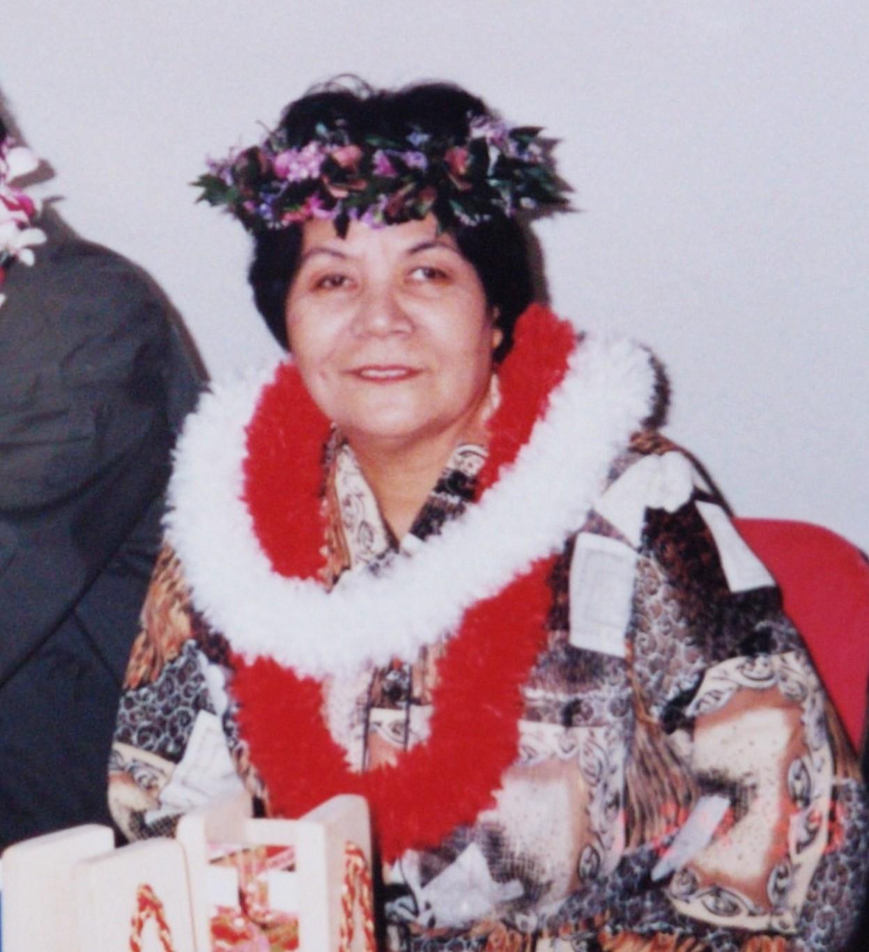 A woman wearing a flower crown and a red and white scarf