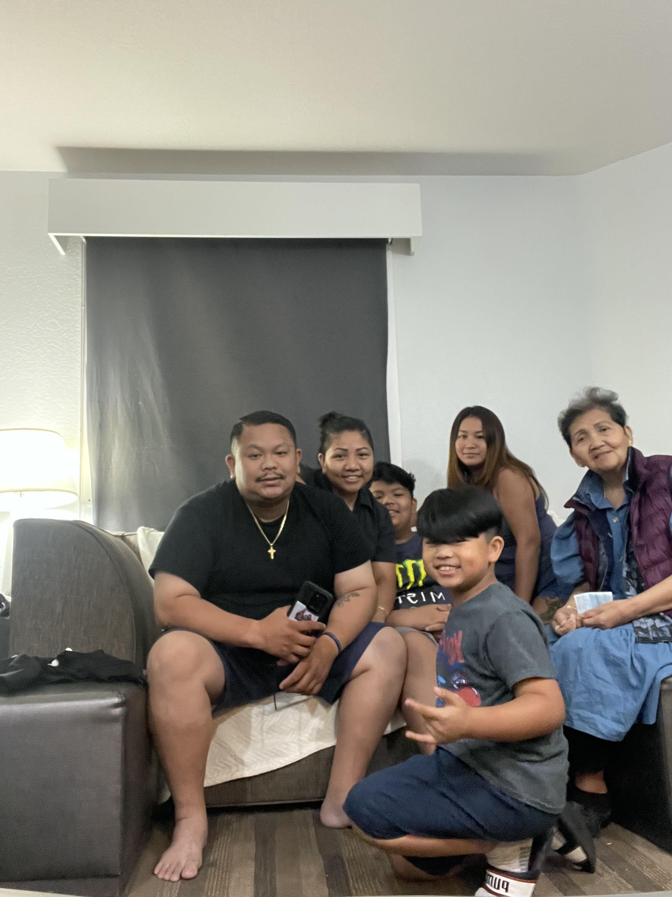 Family members are enjoying time together in a living room, sharing smiles and laughter.