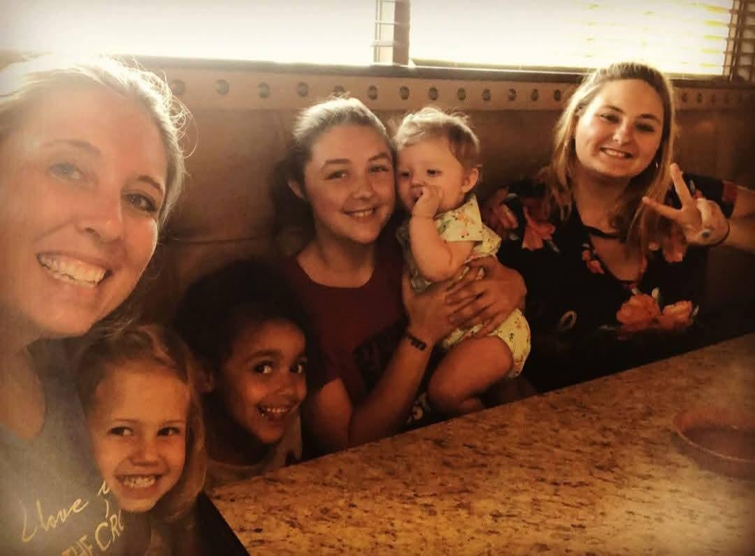 A group of friends enjoy quality time together with children at a cheerful gathering.