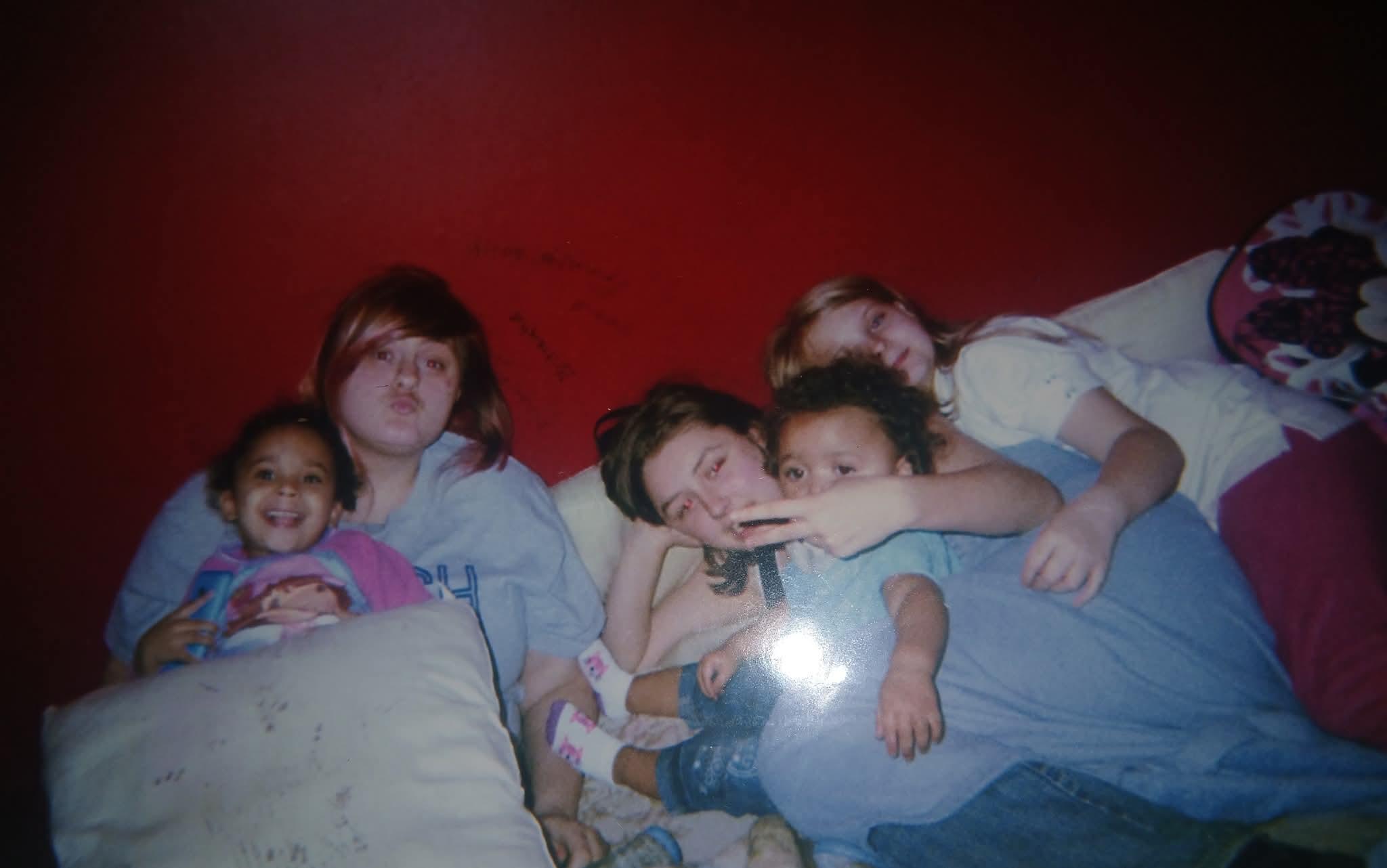Friends gather on a couch, smiling and enjoying each other's company while relaxing.