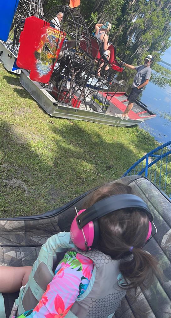 A person wearing headphones and sitting on a boat