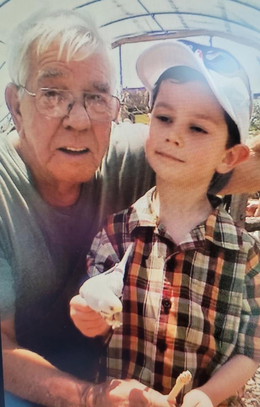 A joyful grandfather and grandson share an ice cream treat while enjoying their time outside.