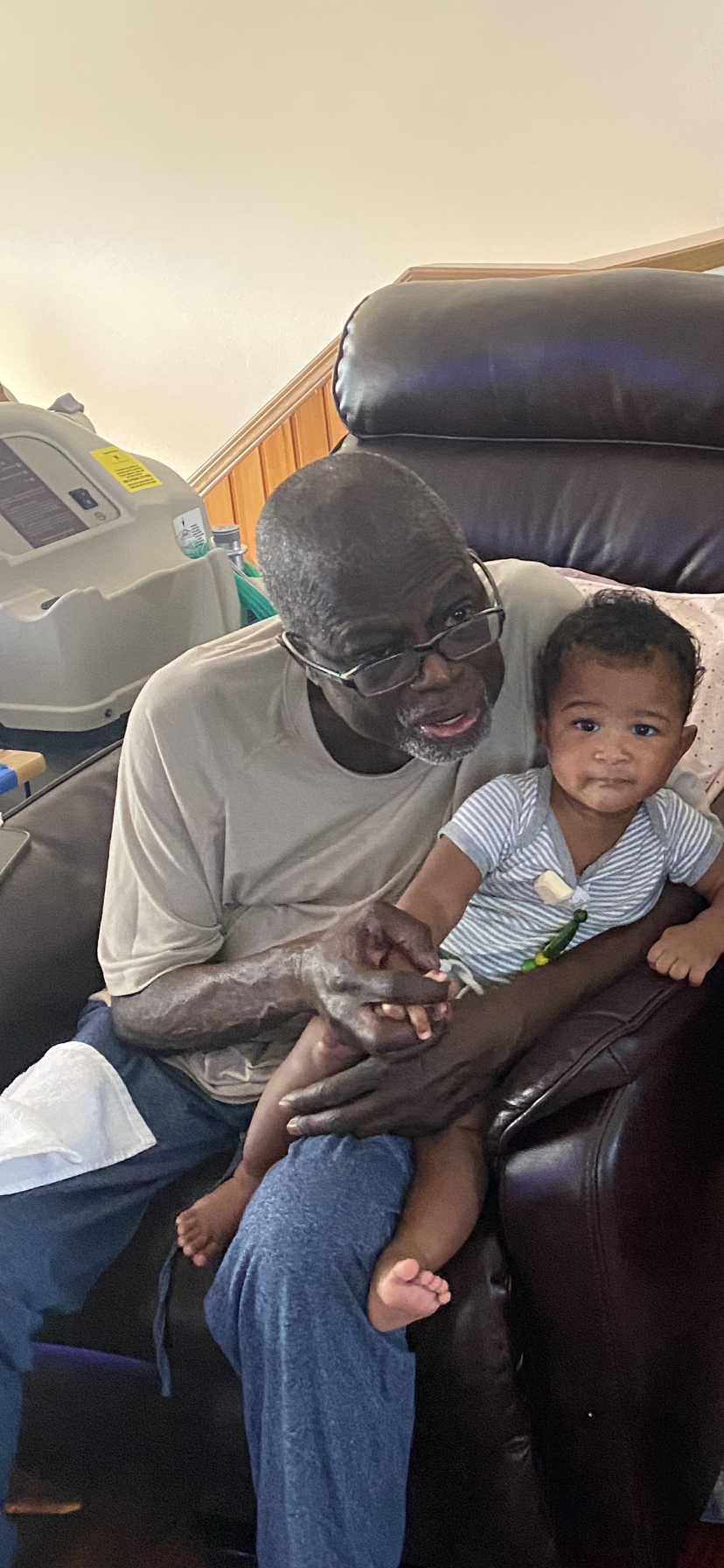 Grandfather and granddaughter share a warm moment in a comfortable living room.