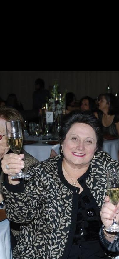 People gather in a banquet hall, joyfully raising champagne glasses during a celebration.