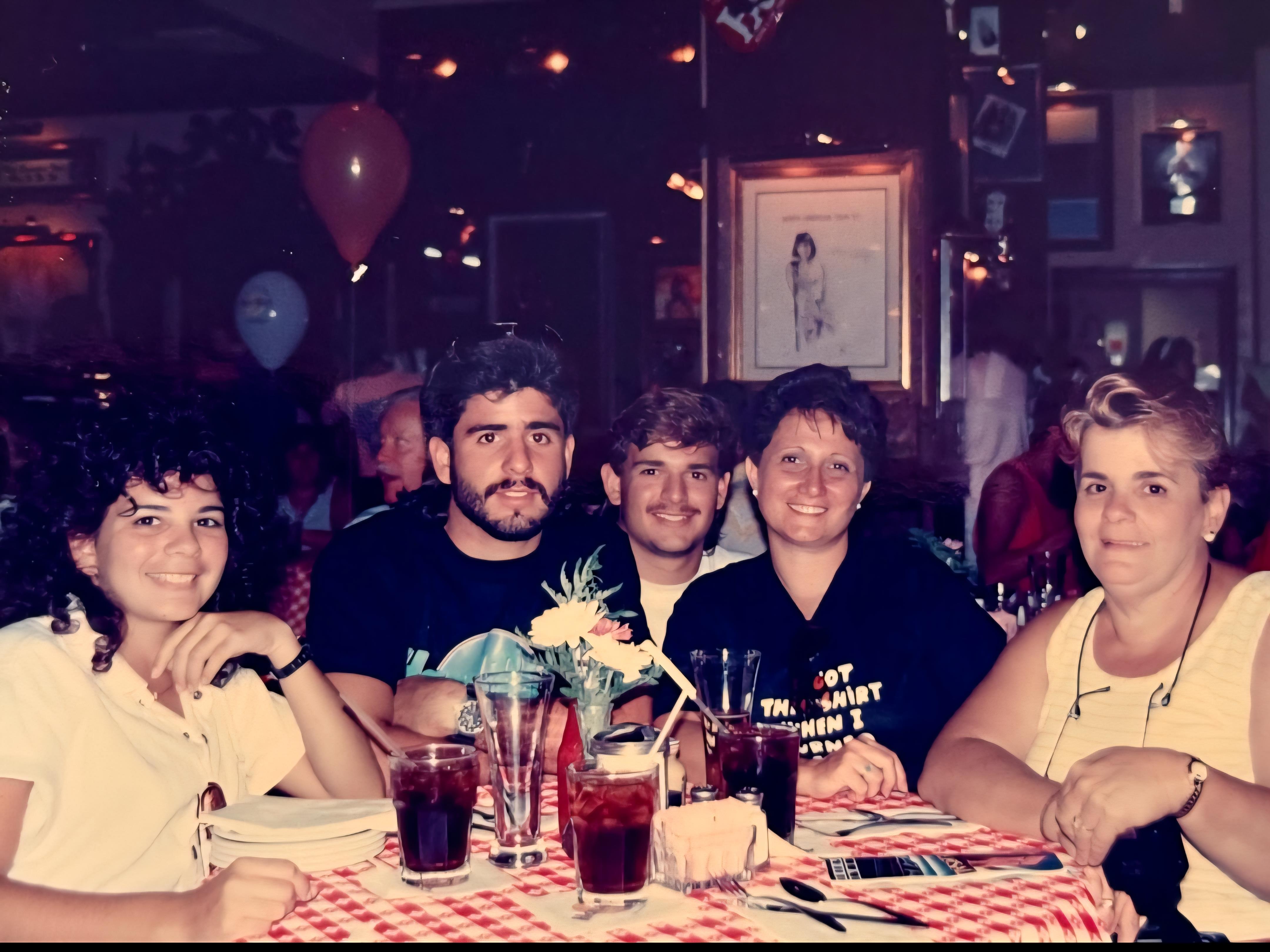 A group of friends enjoying each other's company at a bustling restaurant during a festive night.