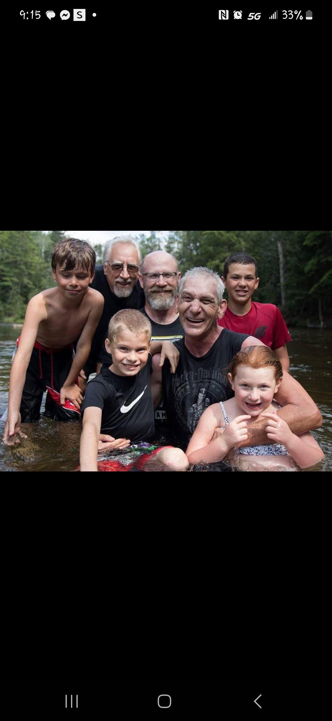 A joyful group of family members enjoys a summer day in a river, capturing moments of togetherness.