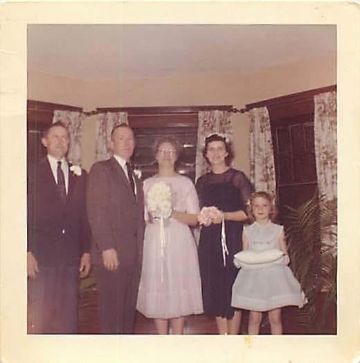 Family members gather together in a cozy living room to celebrate a wedding event.