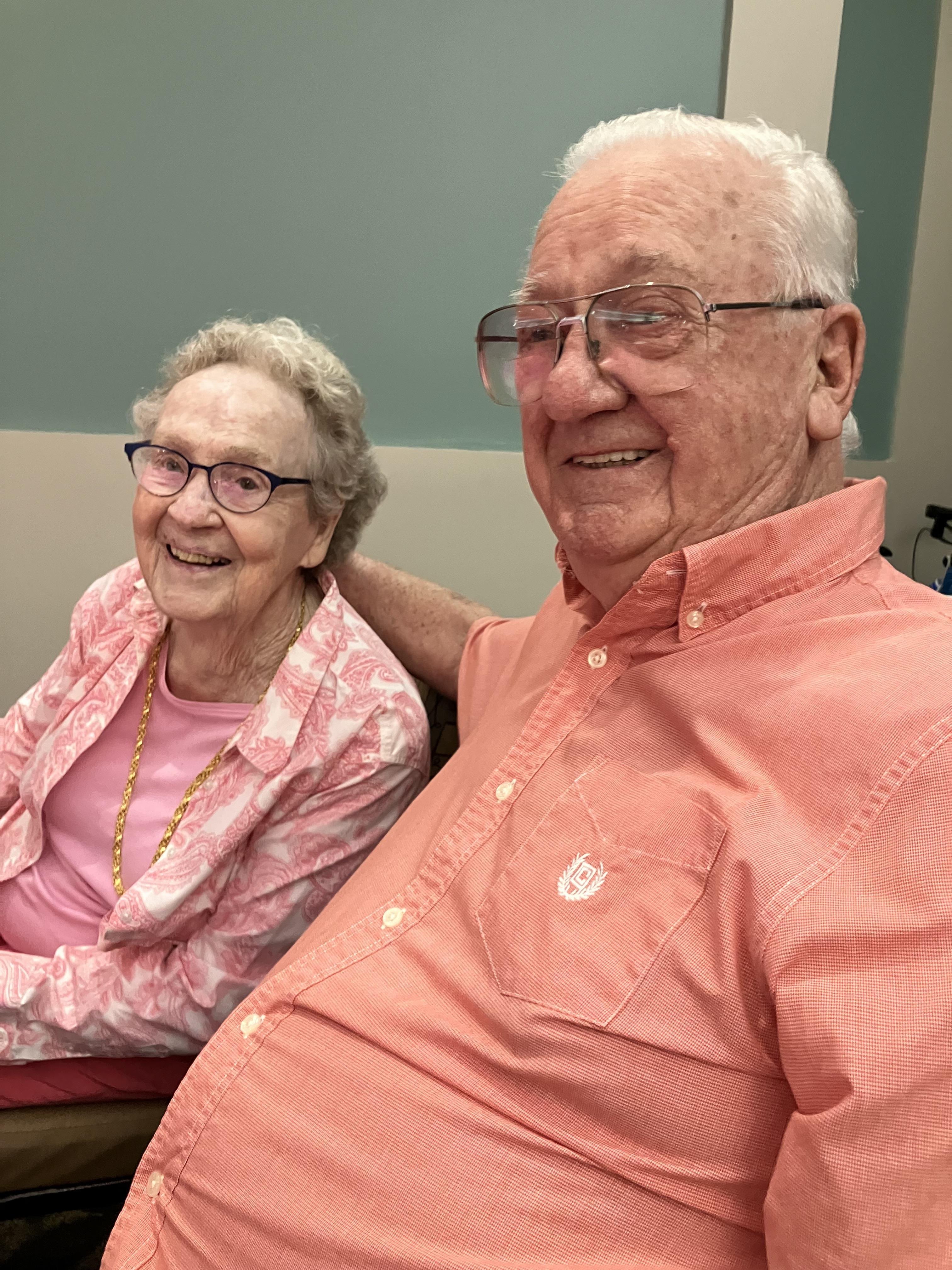 An elderly couple enjoys a heartfelt moment together in a warm, cozy setting.