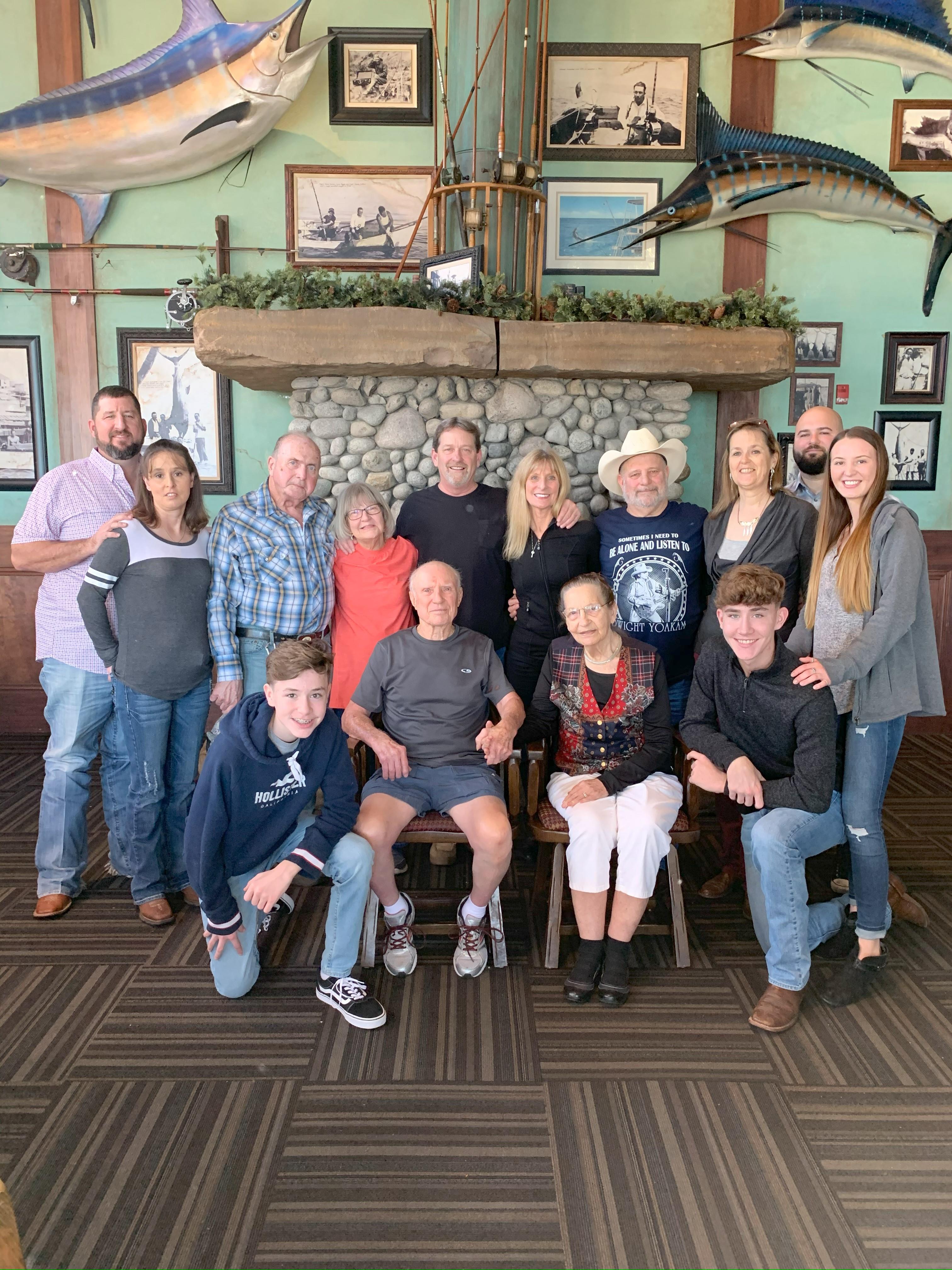 Relatives gather, smiling at a joyful family reunion in a seafood restaurant.