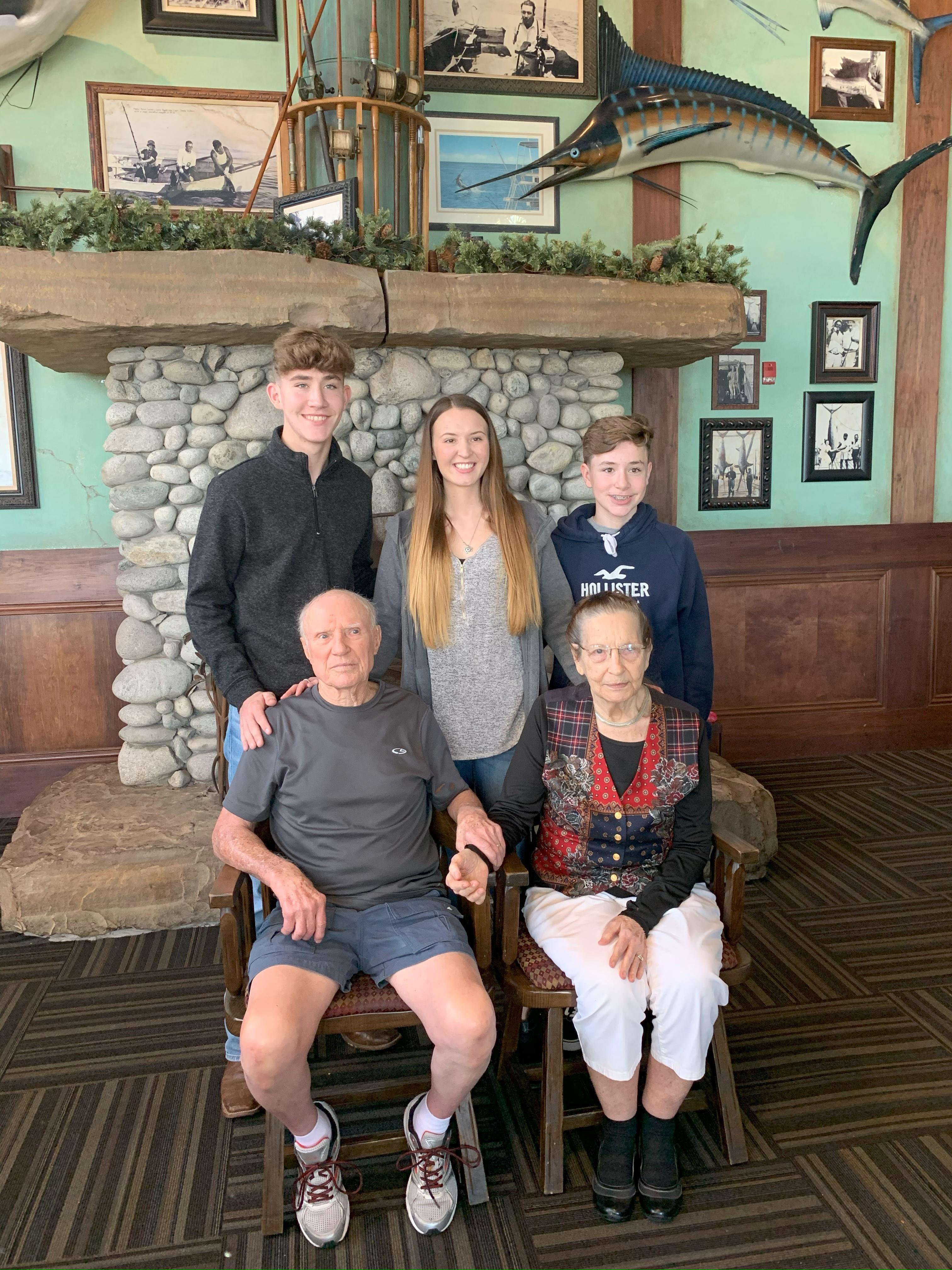 Four family members pose together in a restaurant, a mix of ages highlighting family connections.