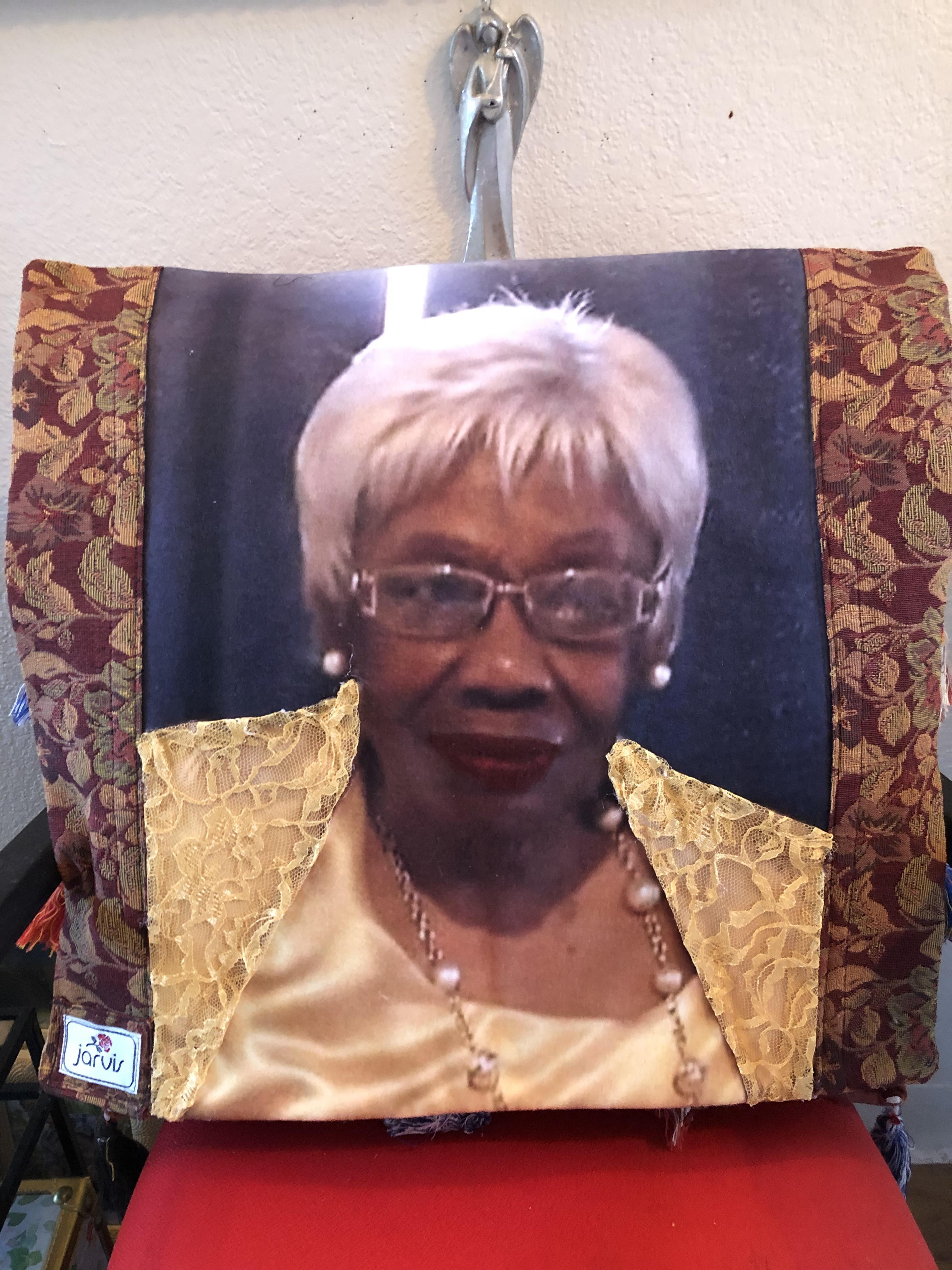 A cushion displays a printed portrait of an elderly woman with white hair, dressed elegantly.