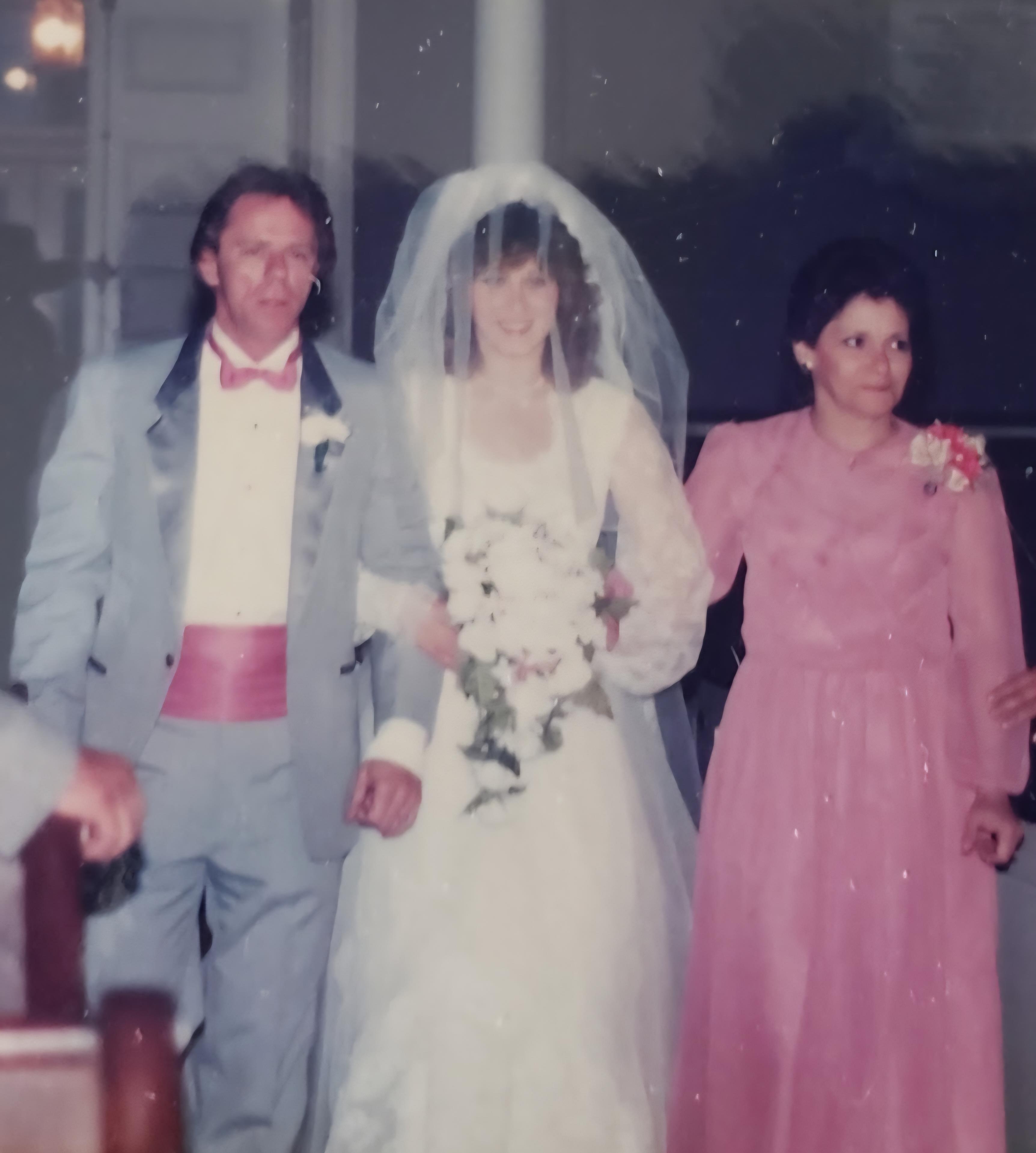A bride and her parents celebrate love in a formal wedding ceremony, surrounded by joy and elegance.