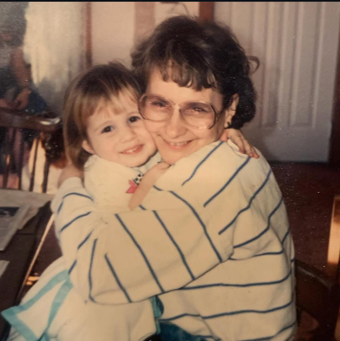 A grandmother and her granddaughter share a heartfelt embrace, surrounded by warmth and love.