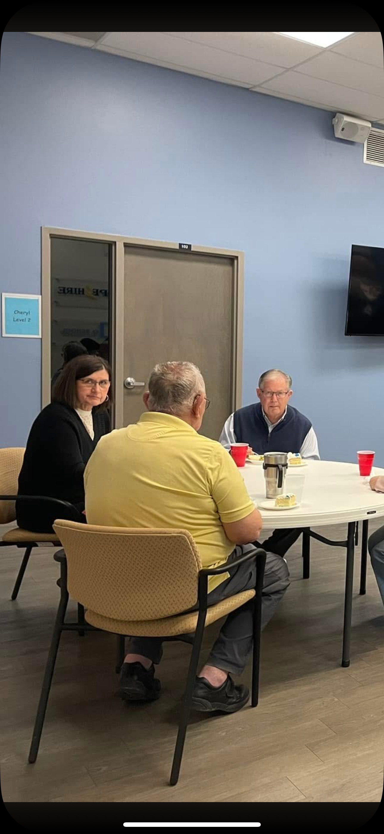 Seniors gather, sharing stories and drinks in a cozy community atmosphere.