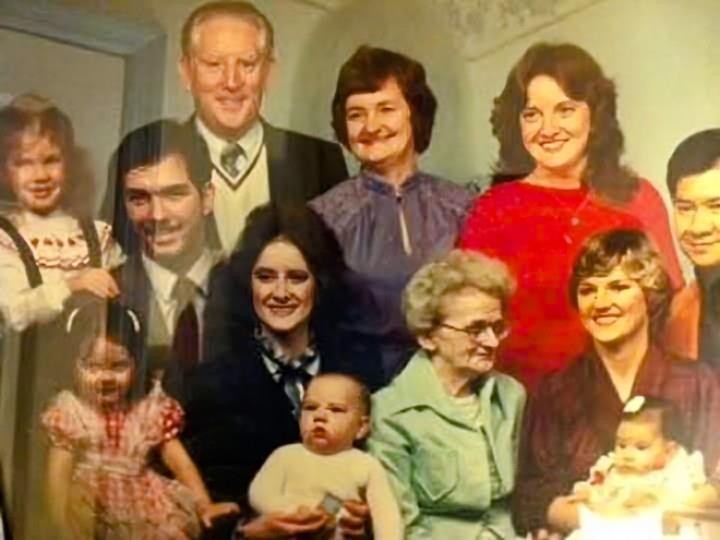 A large family gathers, smiling and sharing a joyful moment of love and connection.