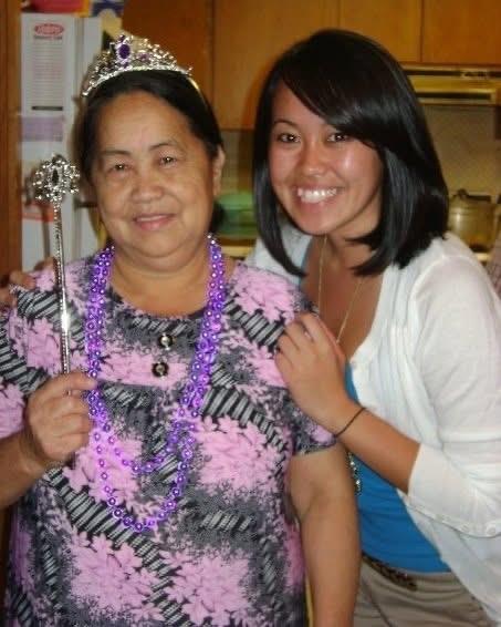 Grandmother in a crown smiles proudly with her granddaughter during a joyful celebration at home.