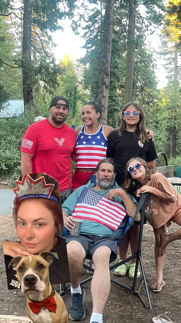 Family members and a dog celebrate together in the forest, enjoying summer and each other's company.