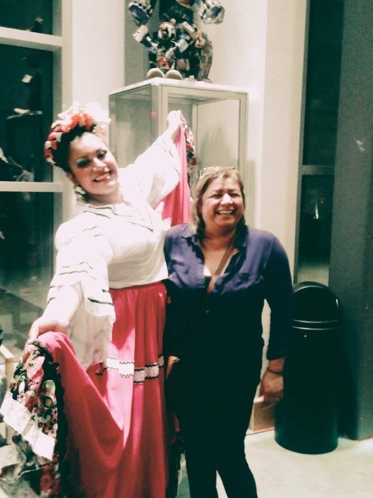 Two women enjoy a joyful moment, showcasing vibrant traditional clothing during a celebration.