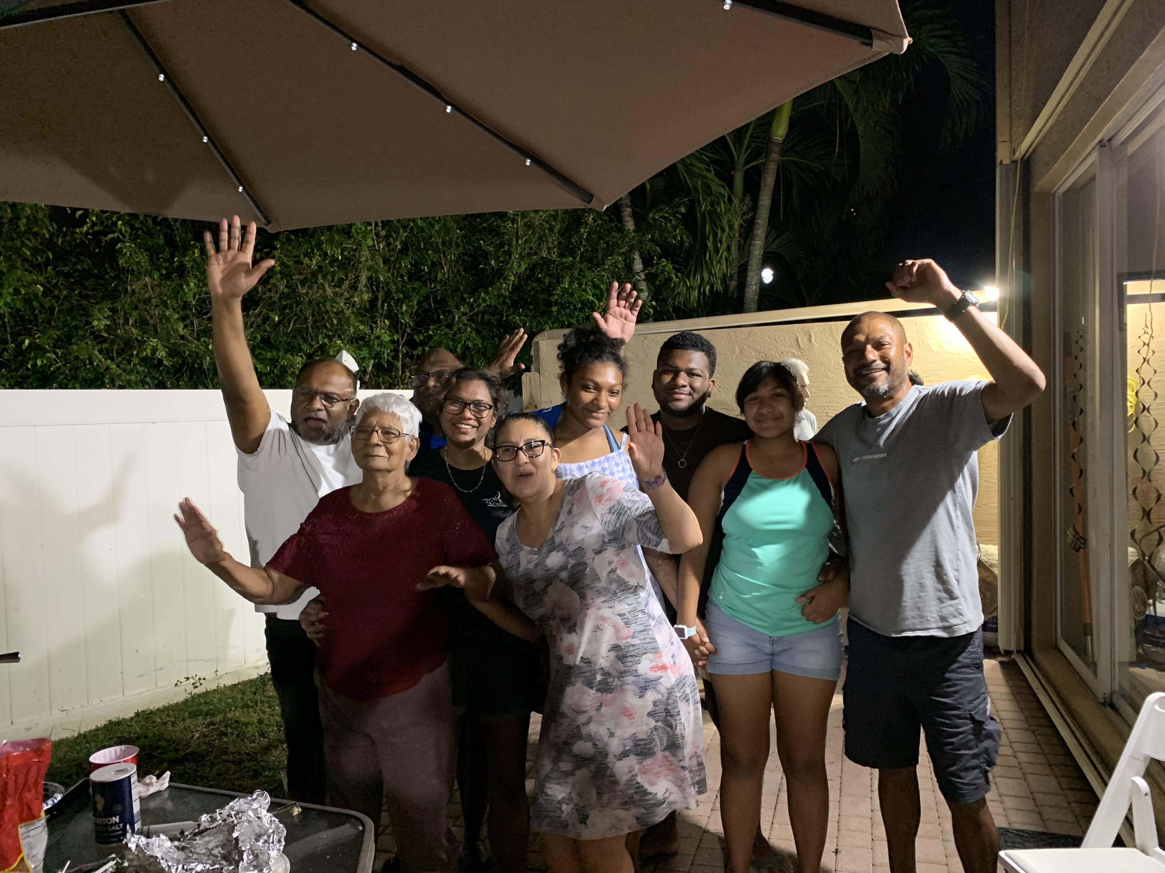 Friends and family celebrate together at night, enjoying each other's company and sharing laughter.