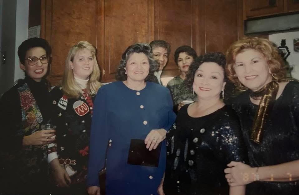 Group of women enjoying each other's company at a festive gathering in a warm, inviting kitchen.