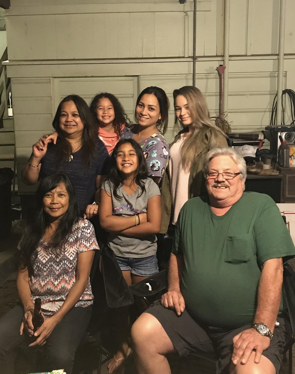 A joyful family enjoys each other's company while posing together indoors at night.
