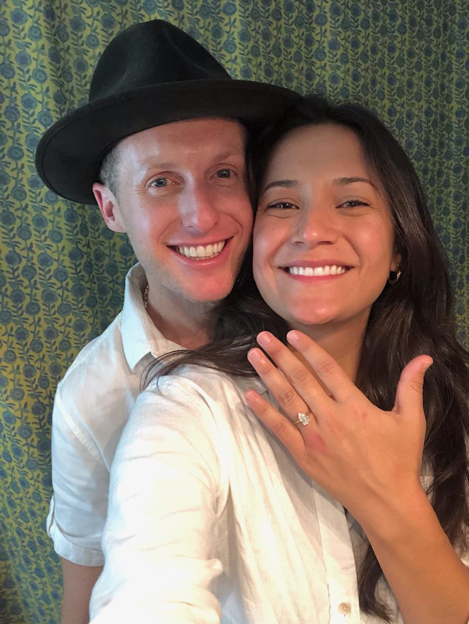 A couple happily showcases an engagement ring, celebrating their commitment to each other together.