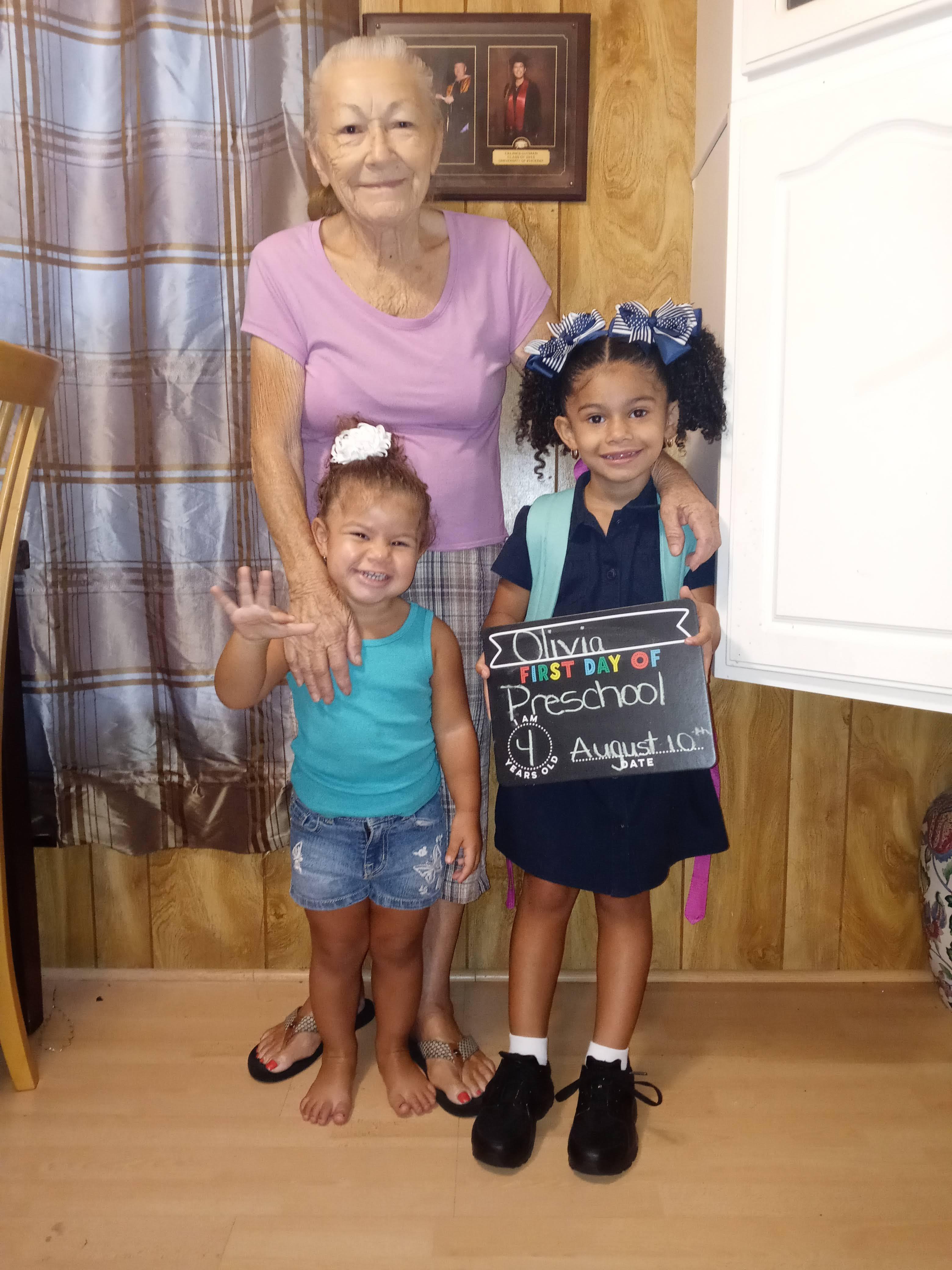 Three generations gather together, smiling and celebrating a special milestone at home.