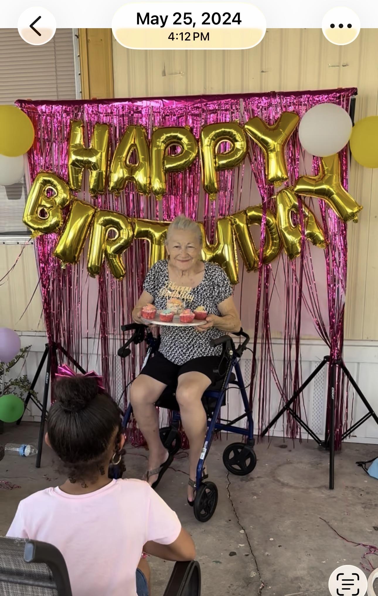 A woman in a wheelchair holding a plate of cupcakes