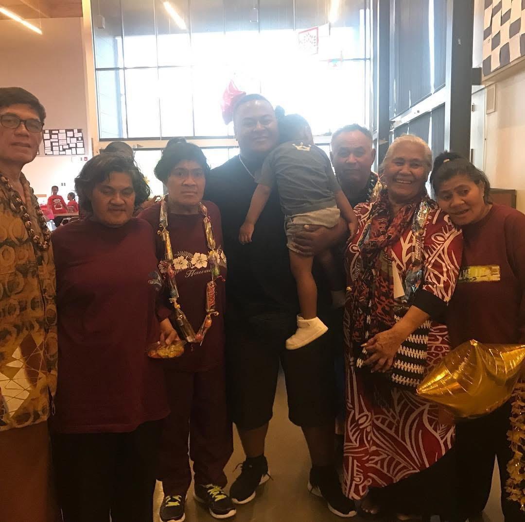 A joyful family gathering in a community hall featuring traditional attire and warm interactions.