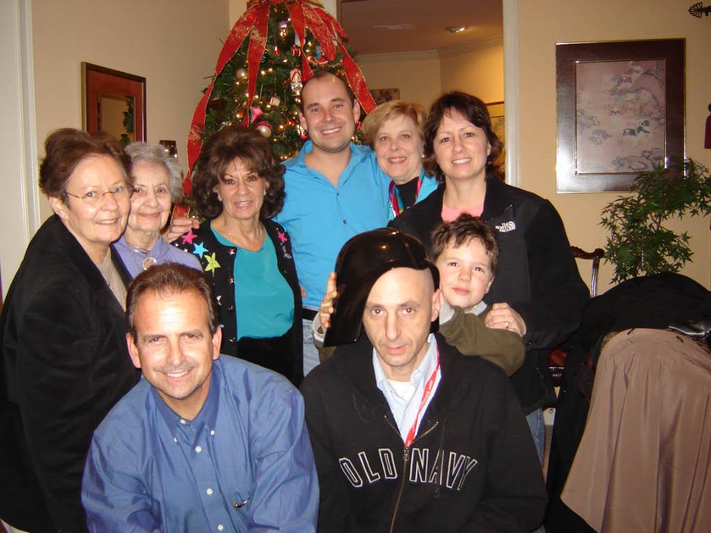 A joyful family shares laughter and smiles by a beautifully decorated Christmas tree.