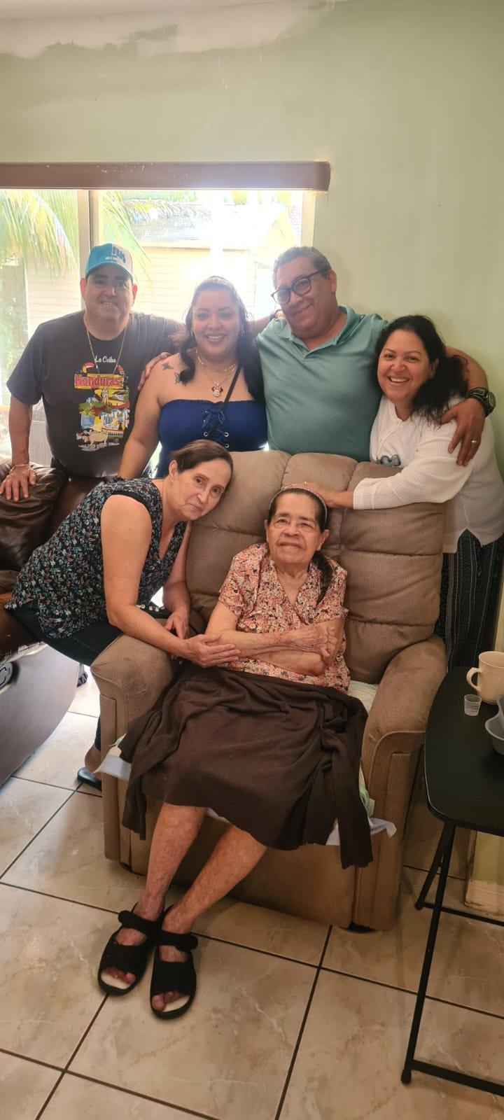 Family members gather in a warm living room, sharing smiles and embracing moments of joy.