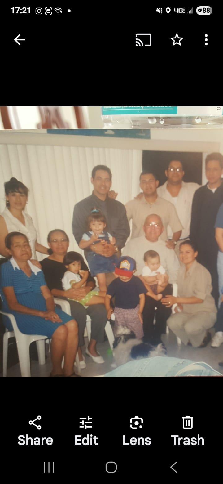 A large family enjoys a joyful gathering, sharing smiles and bonding in a warm indoor space.