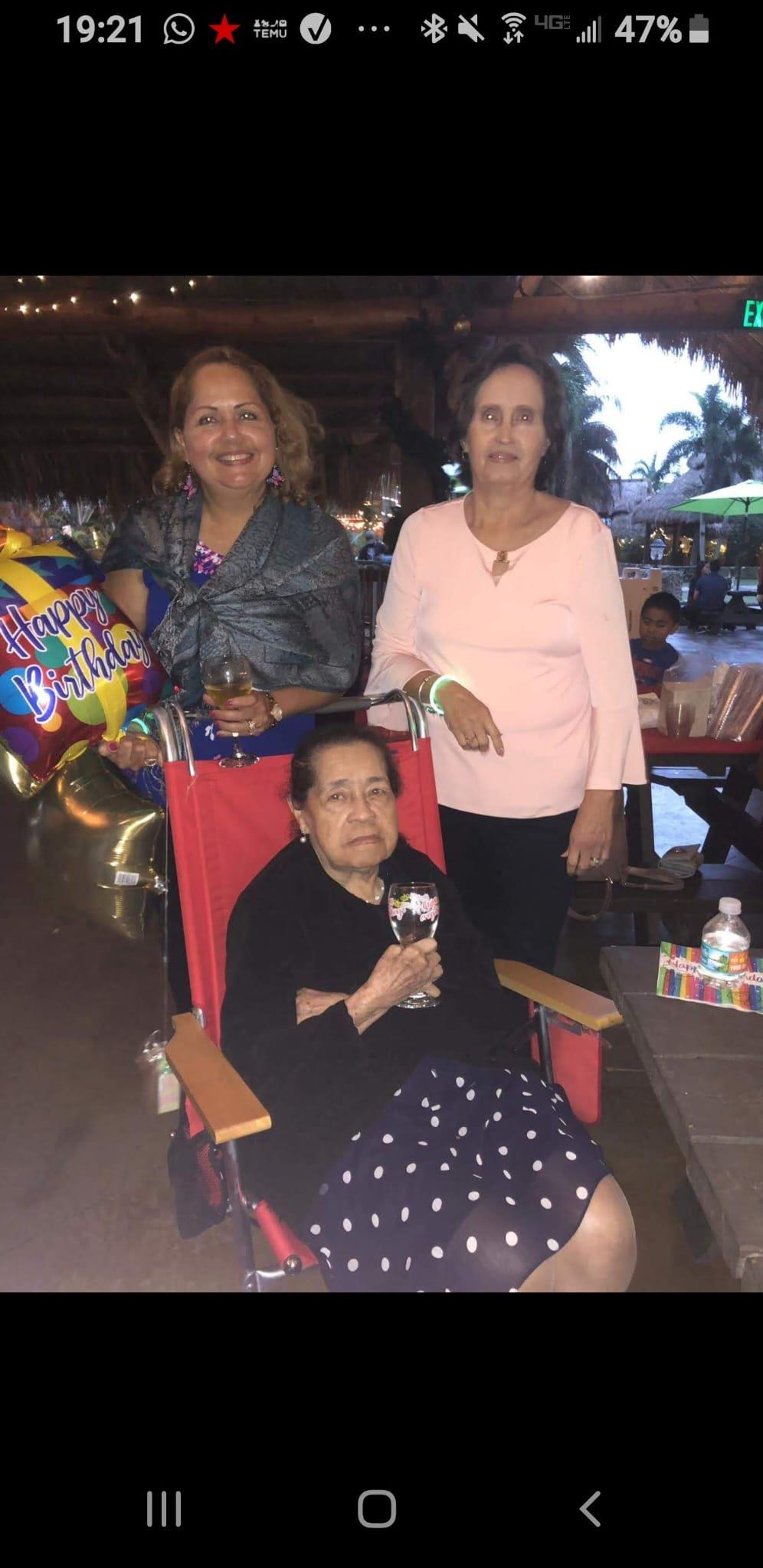 Three family members celebrate a birthday outdoors, enjoying each other's company.