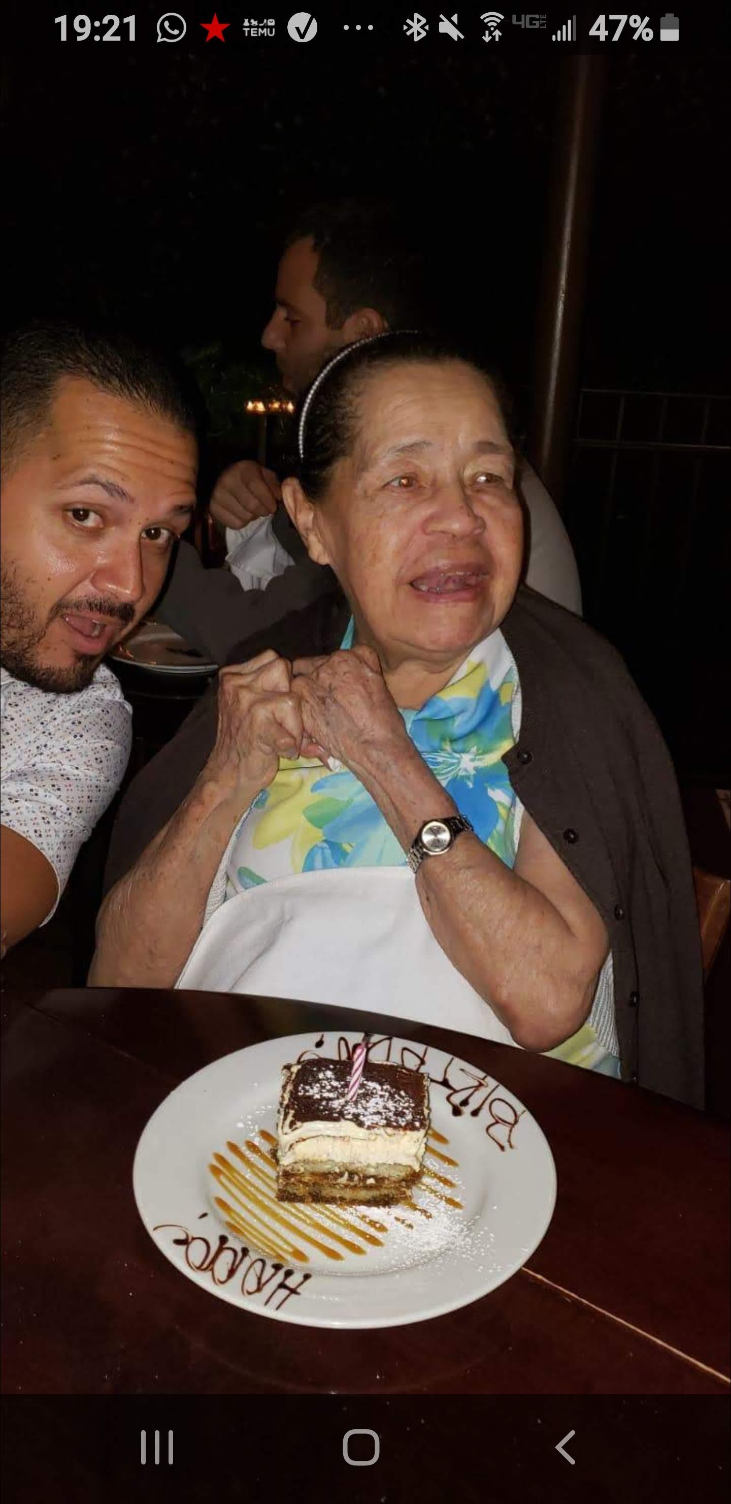 Two people celebrate together at a restaurant, enjoying dessert and sharing laughter in the evening.